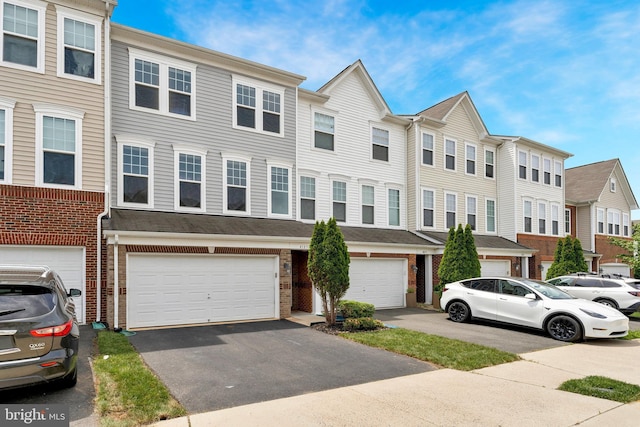 multi unit property with a residential view, brick siding, a garage, and driveway