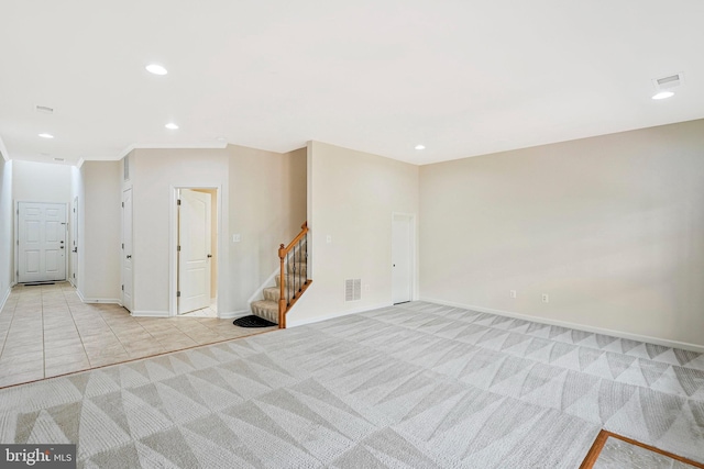 unfurnished room featuring stairs, light carpet, recessed lighting, baseboards, and light tile patterned flooring