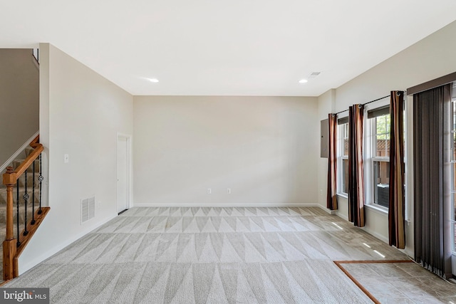 spare room featuring light carpet, stairway, baseboards, and recessed lighting