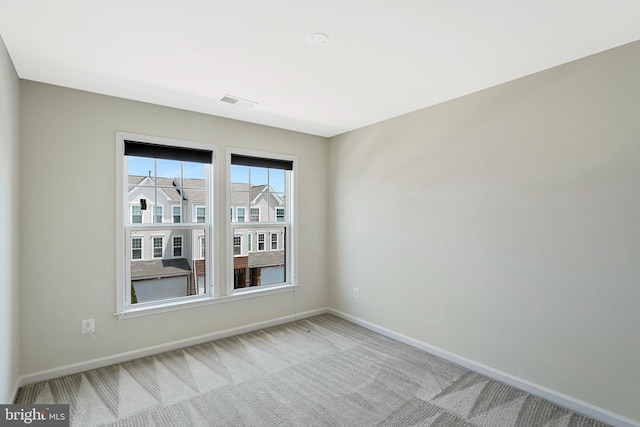 spare room featuring baseboards and carpet flooring