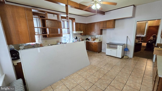 kitchen with ceiling fan, brown cabinets, light tile patterned floors, under cabinet range hood, and light countertops