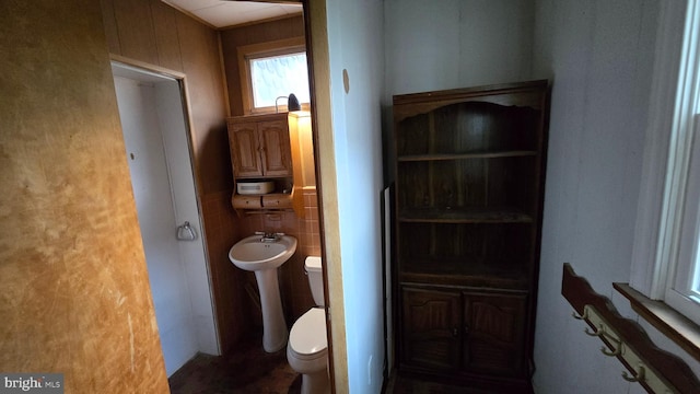 half bathroom with tile walls and toilet