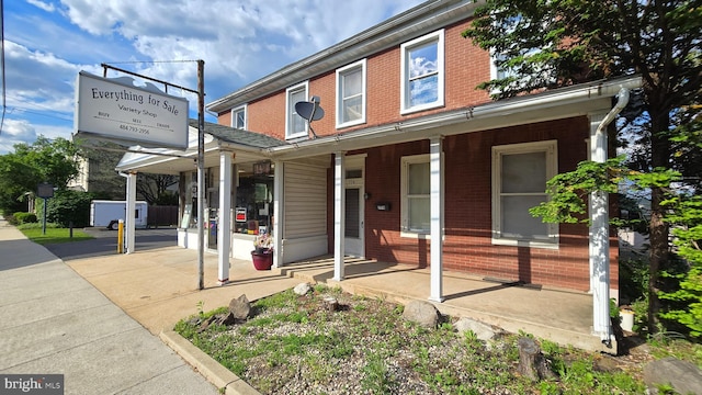view of front facade with covered porch and brick siding