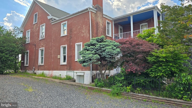 view of side of home featuring brick siding and a chimney