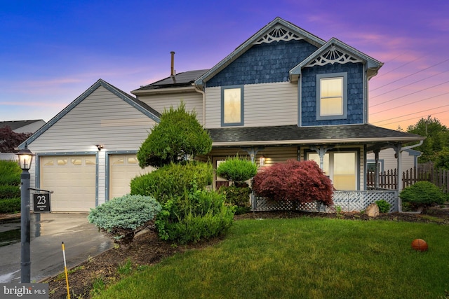 view of front of property with driveway, a garage, a front yard, and a porch