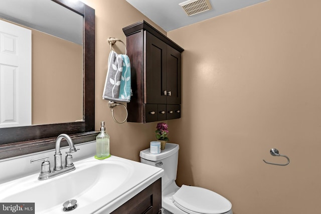 half bath featuring toilet and vanity