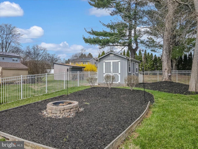 view of yard featuring a fire pit, a shed, and an outbuilding