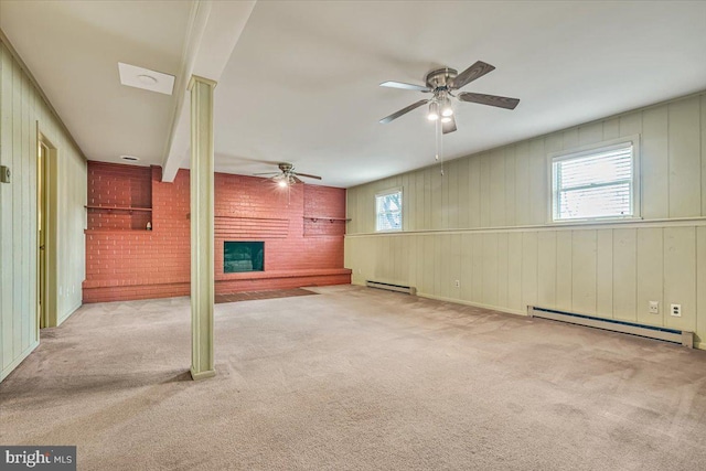 unfurnished living room with a ceiling fan, a fireplace, carpet floors, a baseboard radiator, and brick wall