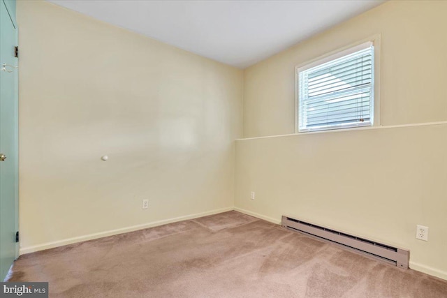 empty room with baseboard heating, carpet floors, and baseboards
