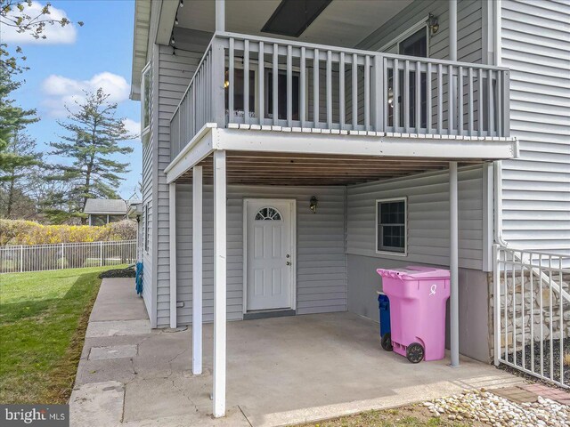 entrance to property with a balcony and fence