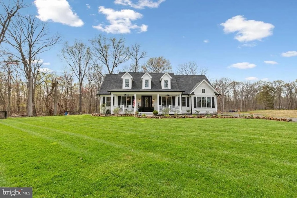 cape cod house featuring a porch and a front yard