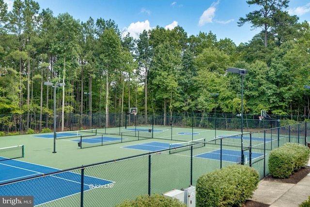 view of tennis court with fence and community basketball court