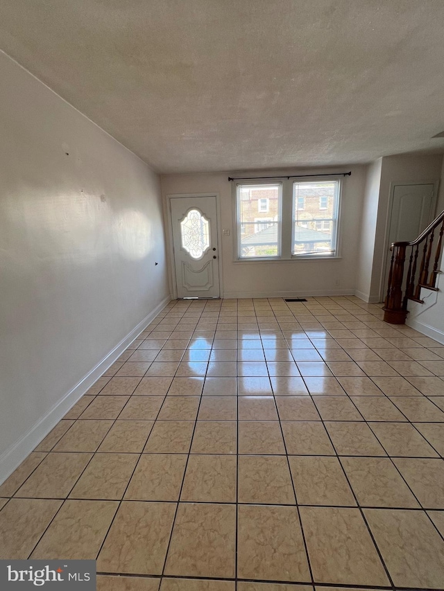 4126 I St, Philadelphia, PA 19124 - entryway with a textured ceiling, stairs, light tile patterned flooring, and baseboards