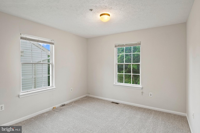 unfurnished room featuring carpet floors, a textured ceiling, and baseboards