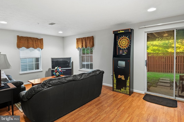 living area featuring healthy amount of natural light, wood finished floors, recessed lighting, and baseboards