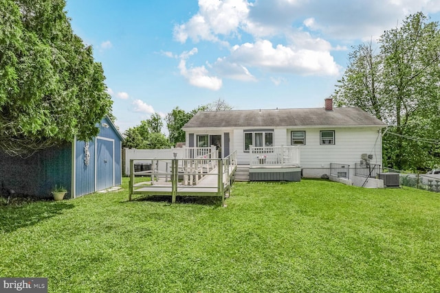 back of house featuring a storage shed, a wooden deck, an outdoor structure, a chimney, and central AC