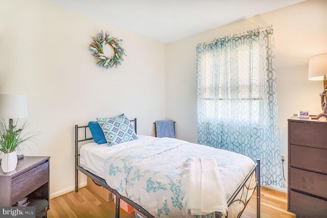 bedroom featuring wood finished floors and baseboards