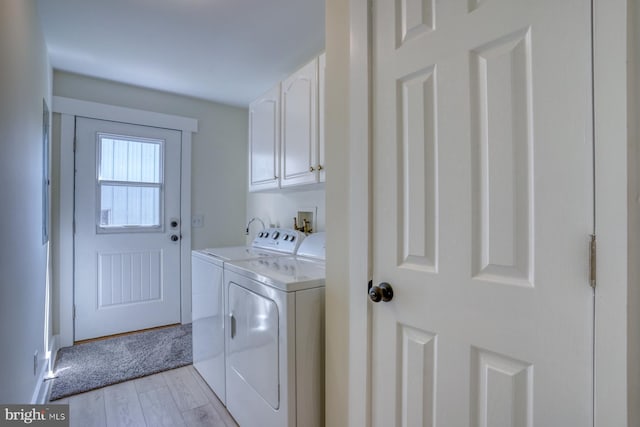 18418 Gravel Hill Rd, Georgetown, DE 19947 - laundry room with cabinet space, washer and clothes dryer, and light wood-style floors
