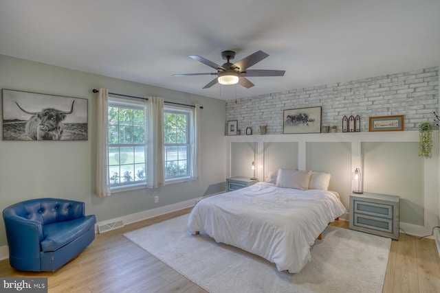 18418 Gravel Hill Rd, Georgetown, DE 19947 - bedroom featuring wood finished floors, brick wall, baseboards, and a ceiling fan