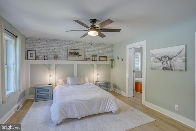 18418 Gravel Hill Rd, Georgetown, DE 19947 - bedroom with wood finished floors, connected bathroom, baseboards, ceiling fan, and brick wall