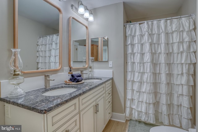 18418 Gravel Hill Rd, Georgetown, DE 19947 - bathroom featuring wood finished floors, double vanity, and a shower with curtain