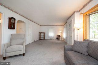 carpeted living room featuring arched walkways