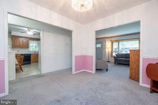 carpeted living area featuring baseboards
