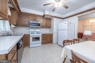kitchen with stainless steel appliances, light countertops, a sink, and ceiling fan