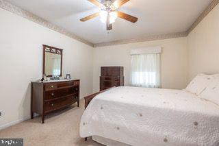 carpeted bedroom with a ceiling fan and baseboards