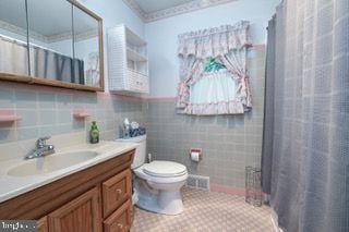 bathroom with toilet, vanity, and curtained shower