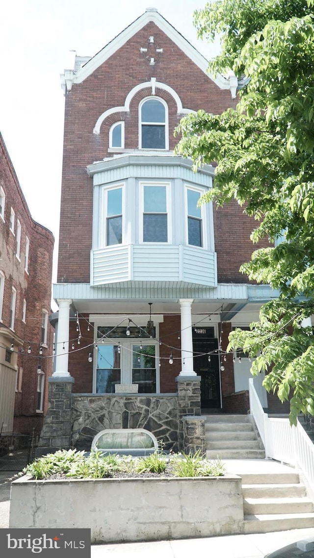 2236 Linden Ave, Baltimore, MD 21217 - view of front facade with a porch, stone siding, and brick siding