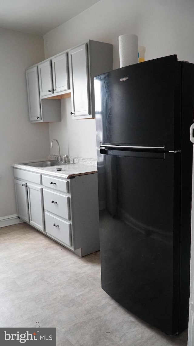 2236 Linden Ave, Baltimore, MD 21217 - kitchen with freestanding refrigerator, a sink, and light countertops