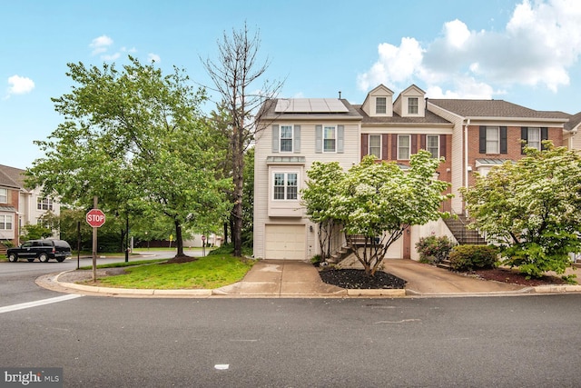 45544 Whitcomb Sq, Sterling, VA 20166 - townhome / multi-family property with solar panels, an attached garage, concrete driveway, stairway, and brick siding