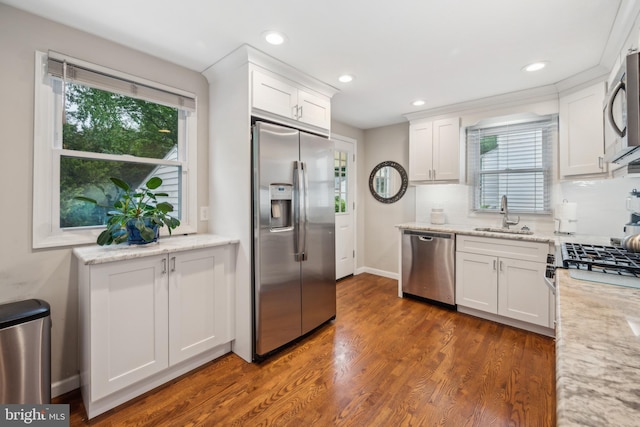 kitchen featuring appliances with stainless steel finishes, a sink, white cabinetry, plenty of natural light, and recessed lighting
