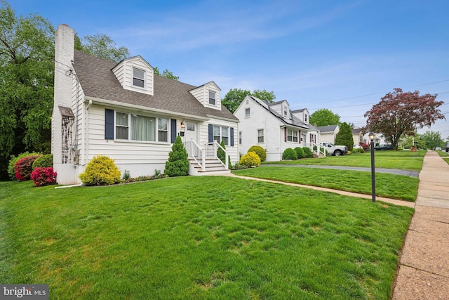 cape cod home with a front yard, a chimney, and roof with shingles