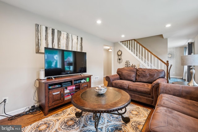 living room featuring stairs, recessed lighting, wood finished floors, and baseboards