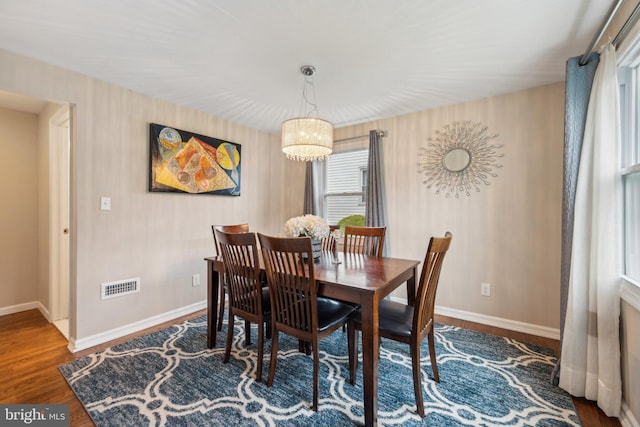 dining area featuring baseboards, wood finished floors, and a chandelier