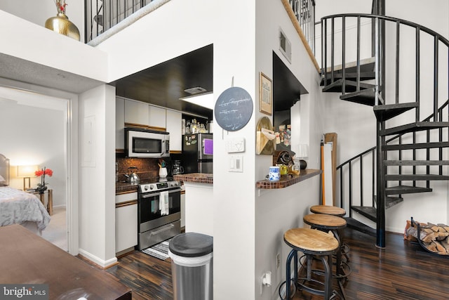1019 Summerglenn Ct Unit 7-302, Bowie, MD 20721 - kitchen featuring appliances with stainless steel finishes, dark wood-style floors, a high ceiling, baseboards, and tasteful backsplash