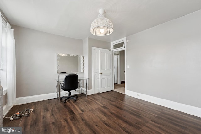 unfurnished office featuring wood finished floors and baseboards