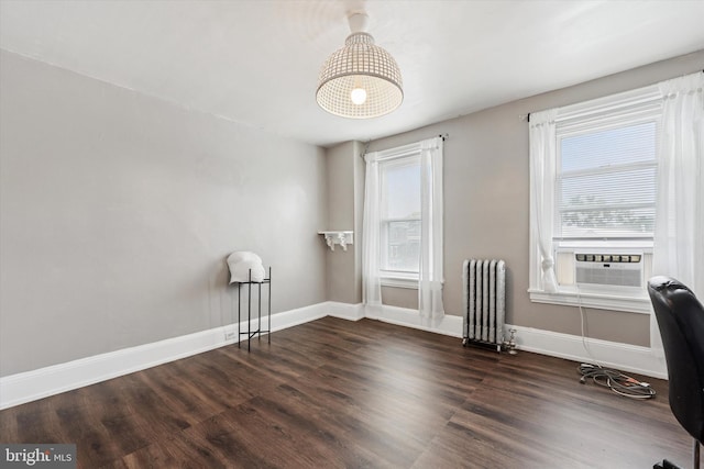 office space featuring radiator, cooling unit, wood finished floors, and baseboards