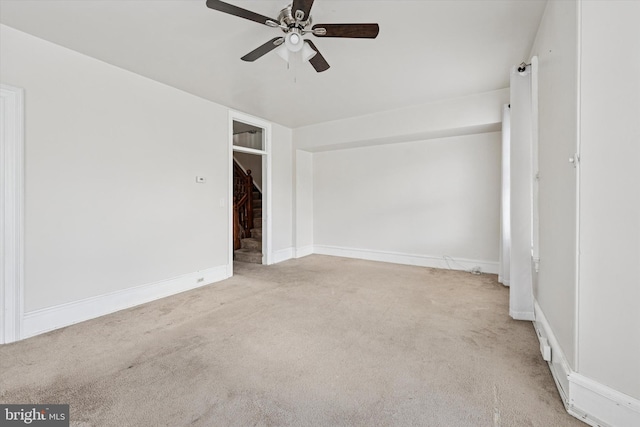 spare room with carpet flooring, a ceiling fan, and baseboards