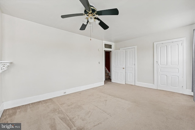 unfurnished bedroom featuring carpet floors, baseboards, and a ceiling fan