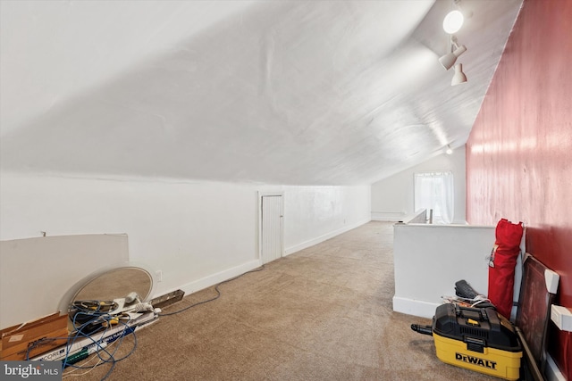 additional living space featuring vaulted ceiling, carpet floors, and baseboards