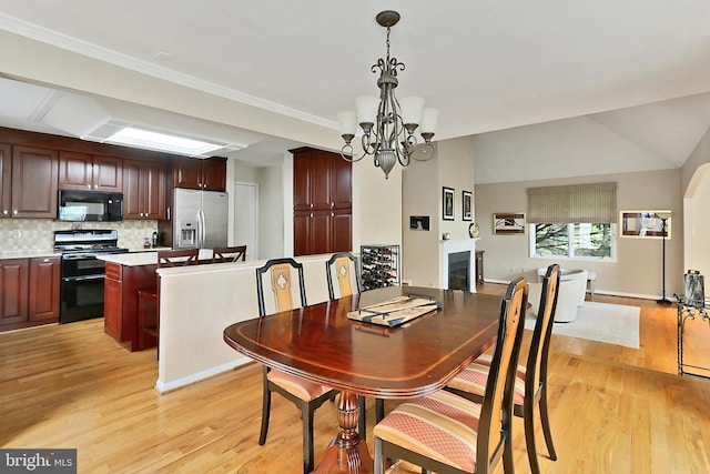 4501 Highland Green Ct, Alexandria, VA 22312 - dining area with light wood-type flooring, a chandelier, ornamental molding, and a fireplace