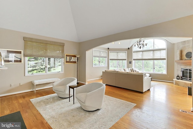 4501 Highland Green Ct, Alexandria, VA 22312 - living room featuring healthy amount of natural light, arched walkways, wood finished floors, a chandelier, and high vaulted ceiling