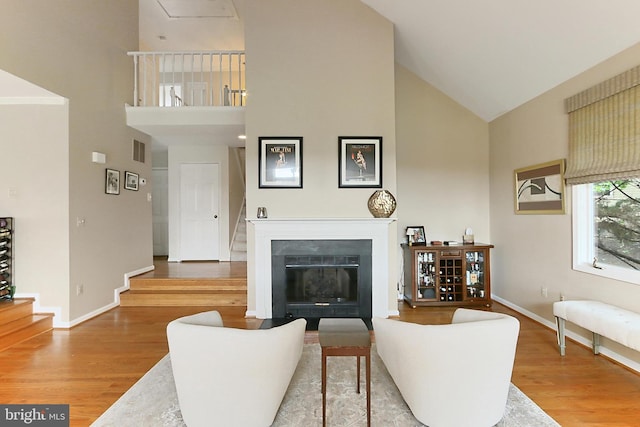 4501 Highland Green Ct, Alexandria, VA 22312 - living area featuring high vaulted ceiling, wood finished floors, stairway, and a fireplace with flush hearth