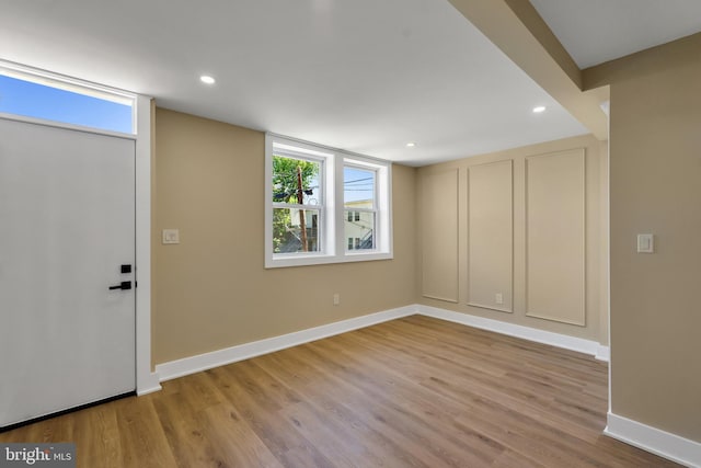 basement with baseboards, wood finished floors, healthy amount of natural light, and recessed lighting