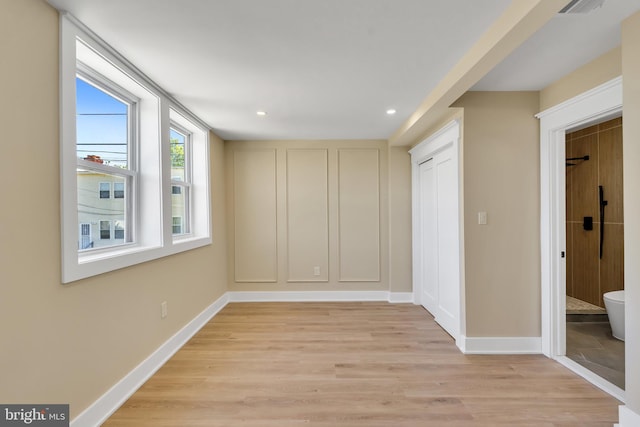 unfurnished bedroom with light wood finished floors, baseboards, recessed lighting, and a closet