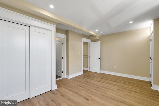 unfurnished bedroom featuring baseboards, light wood-style flooring, recessed lighting, and a closet