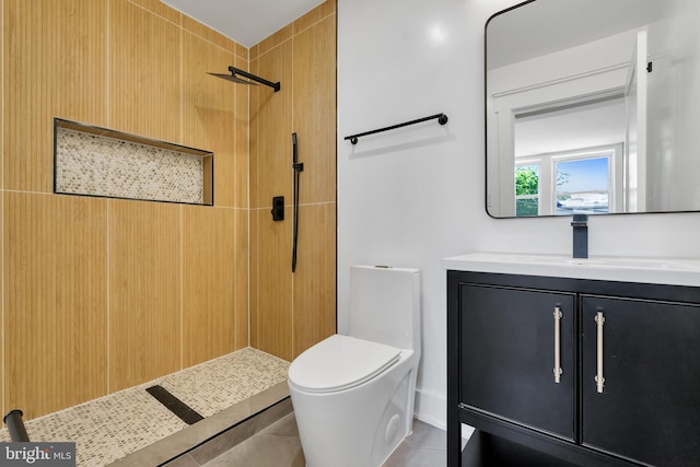 full bath with tiled shower, vanity, toilet, and tile patterned flooring